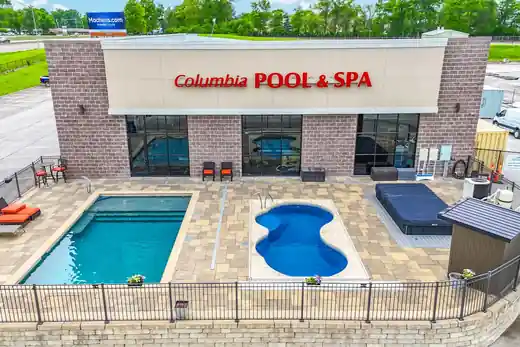 The Columbia showroom exterior with a fiberglass rectangle pool and a kidney-shaped shell displayed on the patio