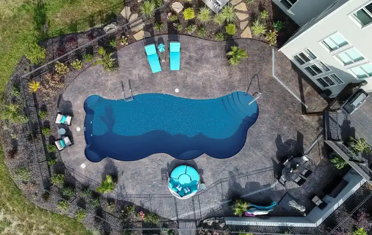 Aerial view of a freeform fiberglass pool with a round spa