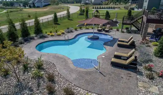 Freeform pool with loungers and a pergola