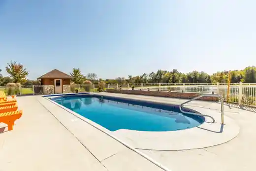 Pool at the lakeside with orange chairs along the deck